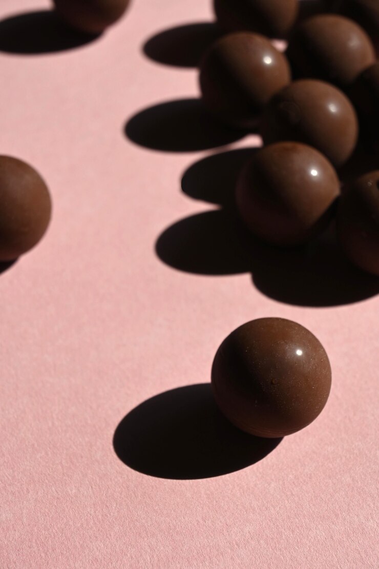 Close-up of chocolates with hard shadows, abstract aesthetics. Select focus