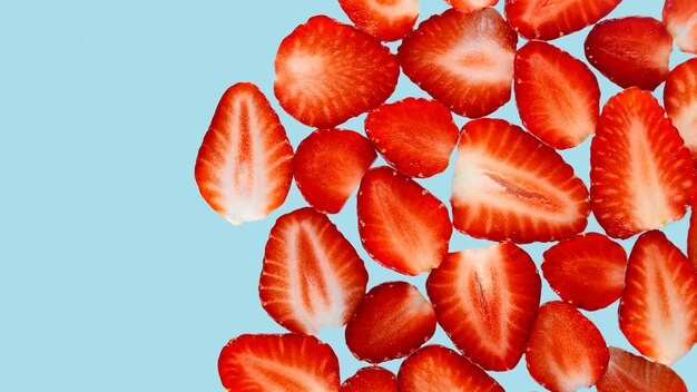Photo close-up of chopped strawberries against blue background copy space banner