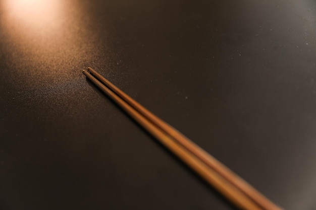 A close up of chopsticks on a black table