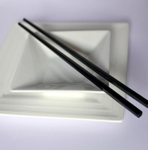 Photo close-up of chopsticks and bowl on table