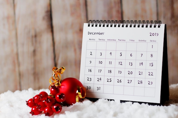 Photo close-up of christmas decoration and calendar on table