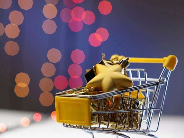 Close-up of christmas decorations in shopping cart against defocused lights