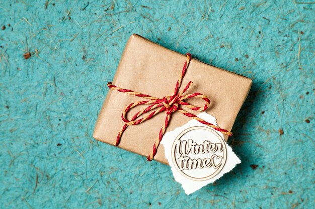 Close-up of Christmas gift box with winter time inscription on a blue background