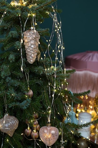 Close up Christmas and New year fir tree decoration with garland lights and shining pine cone