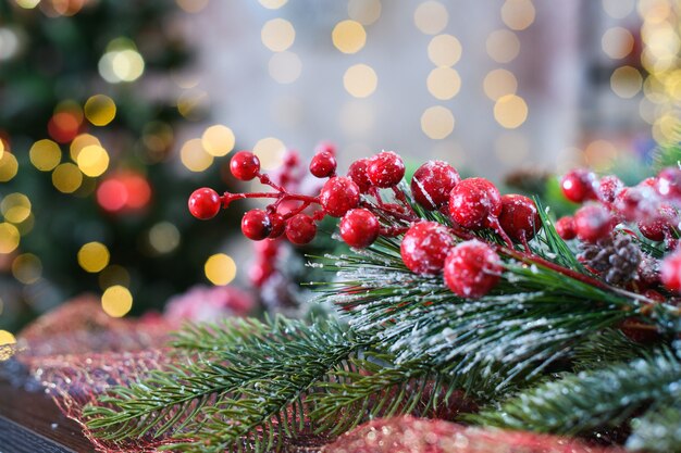 雪に覆われた、背景に軽いボケ味のガマズミ属の木の赤いベリーの装飾でクリスマスと新年の木をクローズアップ