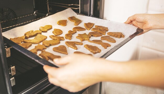 Foto primo piano di pasticcini di natale biscotti di pan di zenzero pronti per cucinare la tradizionale pasticceria di natale e capodanno su carta bianca xa