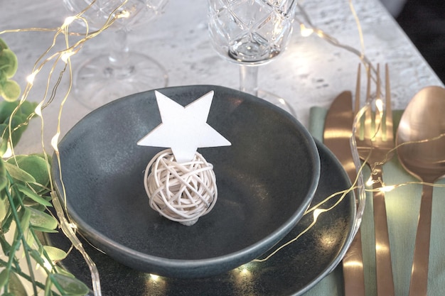 Close up of Christmas star place card on the black plate Modern Scandinavian Table Settings