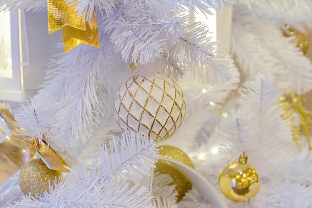 Close up of christmas tree decorated with sparkling balls and garland with lights on Festive background with copy space for your projects