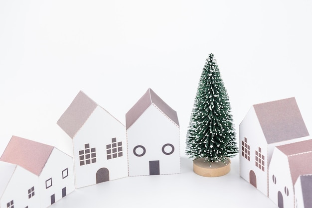 Photo close-up of christmas tree and model homes against white background