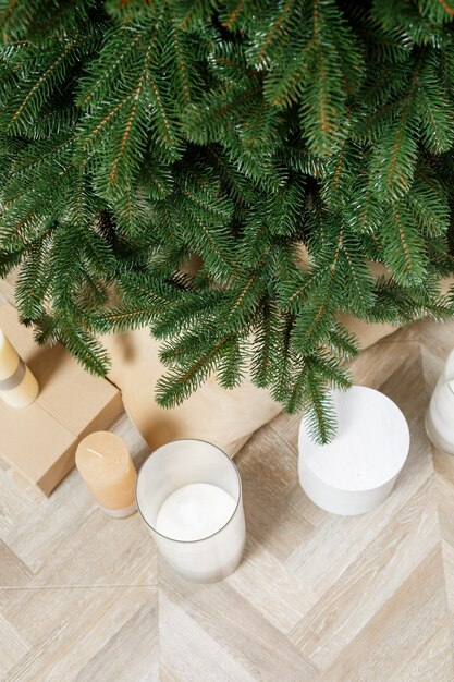 Close-up Christmas tree without toys. Good New Year spirit. Green branches of a Christmas tree with gifts and candles