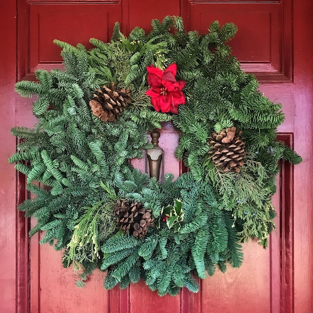 Close-up of christmas wreath on red door