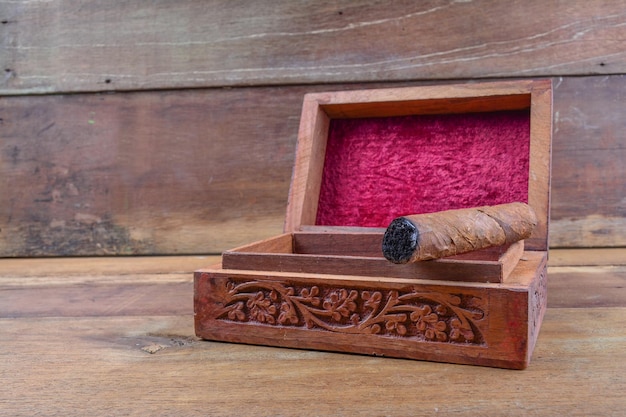 Close-up of cigar on wooden box