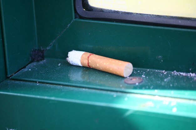 Photo close-up of cigarette butt on window sill