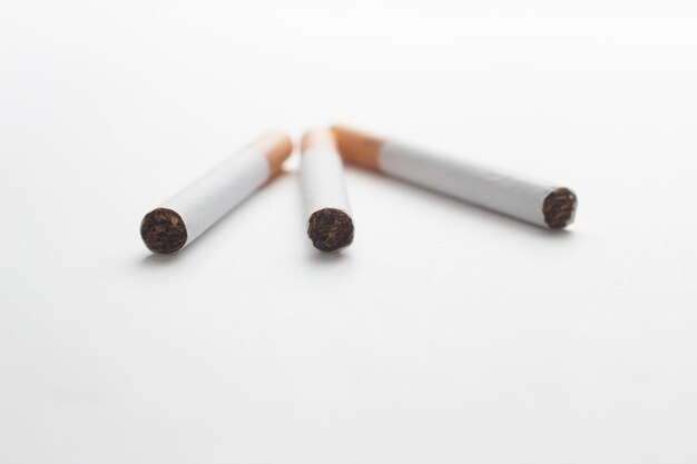 Photo close-up of cigarettes over white background