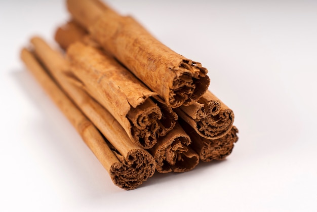 Close up of cinnamon sticks on white surface