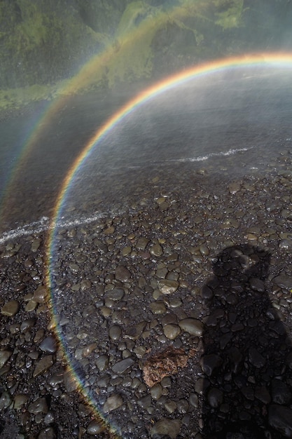 Foto chiuda in su cerchio arcobaleno sopra foto di concetto di ruscello poco profondo