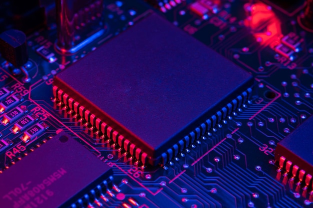 A close up of a circuit board with a blue and red light behind it