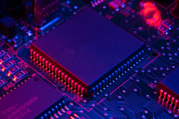 a close up of a circuit board with a blue and red light behind it.