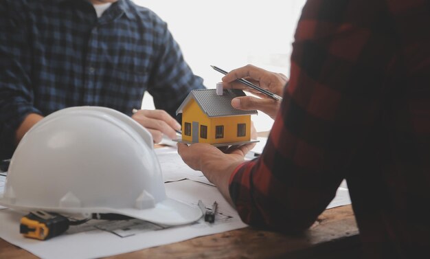 Close up of civil male engineer asian working on blueprint architectural project at construction site at desk in office