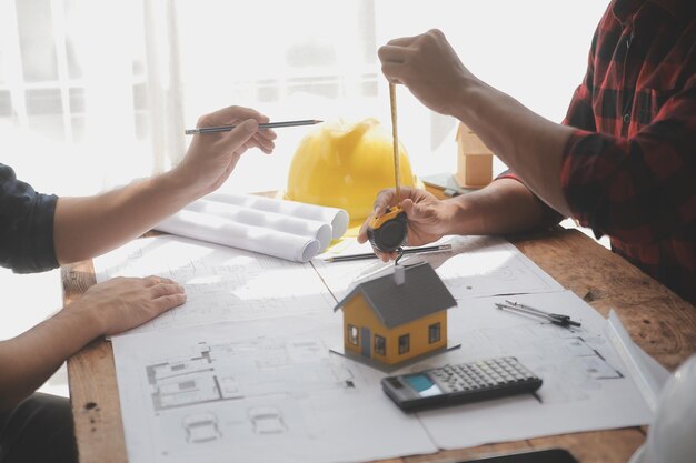 Close up of civil male engineer asian working on blueprint architectural project at construction site at desk in office