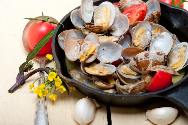 close-up of clams by tomatoes and garlic on table