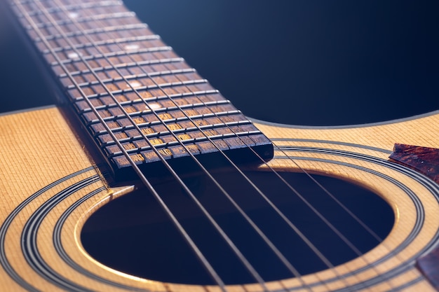 Primo piano di una chitarra acustica classica su uno sfondo sfocato con bokeh.