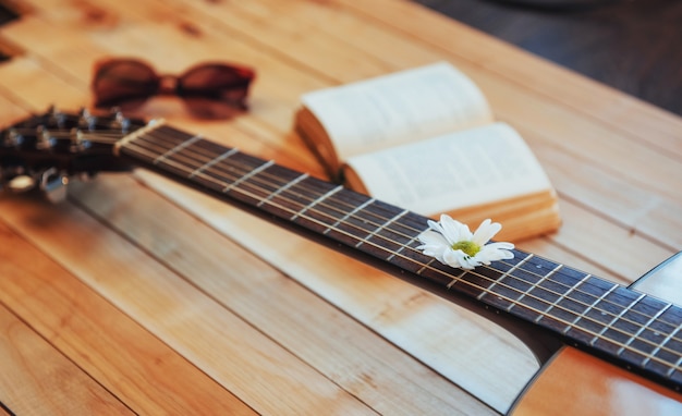 Close up classical guitar head with glasses and book