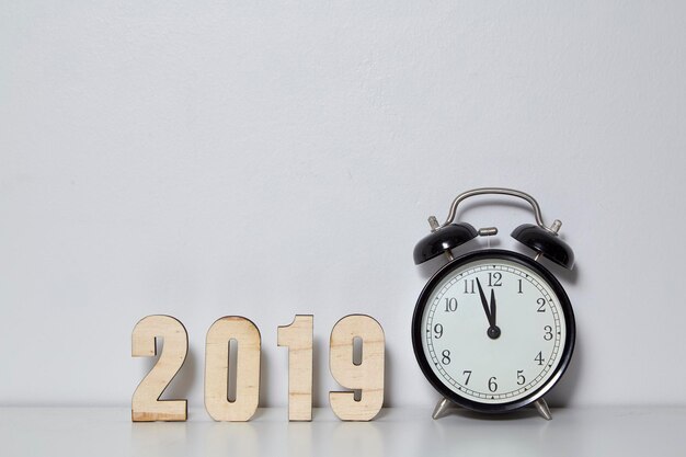 Photo close-up of clock and 2019 on table against wall