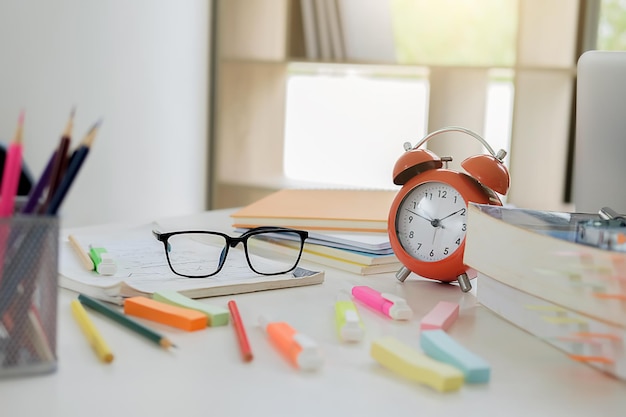 Photo close-up of clock amidst stationery on table