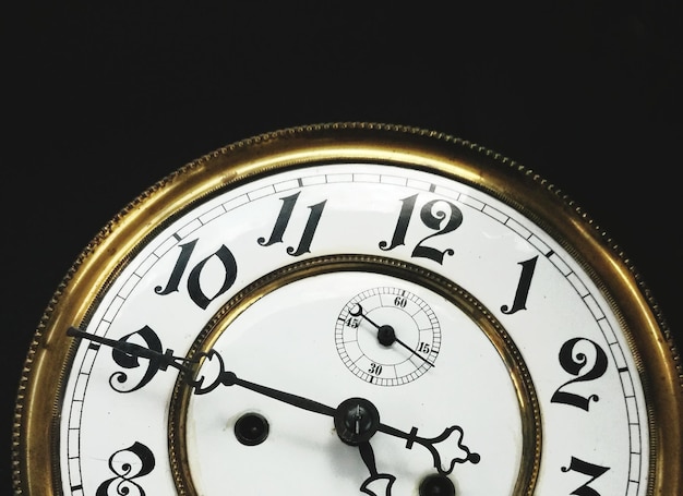 Photo close-up of clock over black background