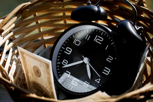 Close-up of clock and paper currency in wicker basket