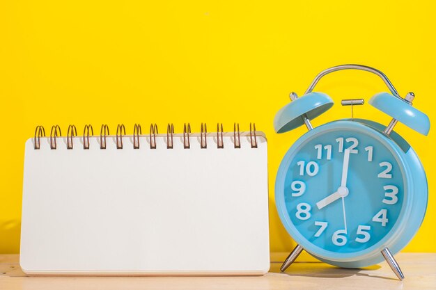 Close-up of clock on table against yellow background