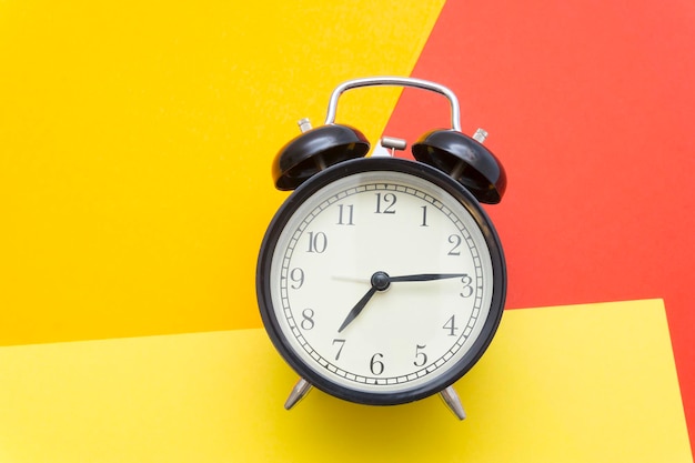 Close-up of clock on table against yellow wall