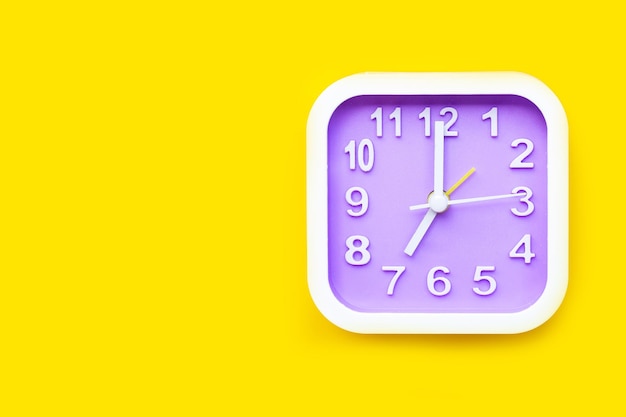 Close-up of clock on yellow background