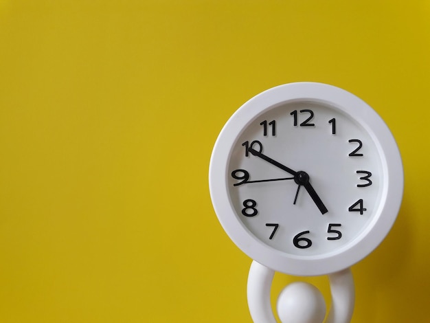 Close-up of clock on yellow wall