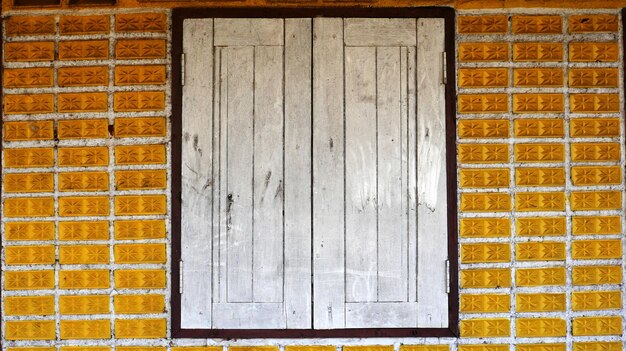 Close-up of closed window on brick wall