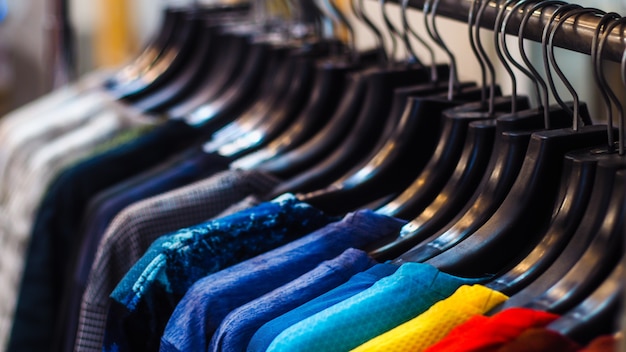 Close up clothes hang on clothes rack in clothing store