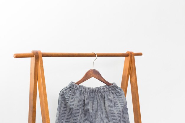 Close-up of clothes hanging on wood against white background