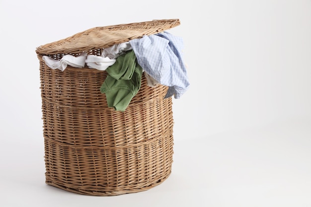 Photo close-up of clothes in laundry basket over white background