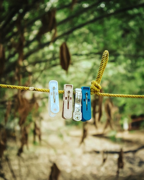 Photo close-up of clothespins hanging on rope