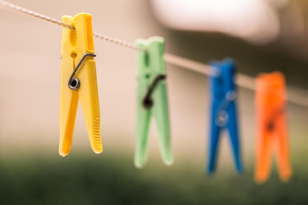 Photo close-up of clothespins hanging on rope