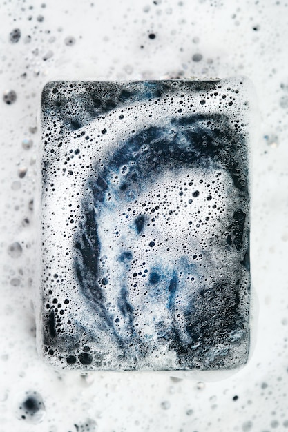 Close up on coal soap bar in foam