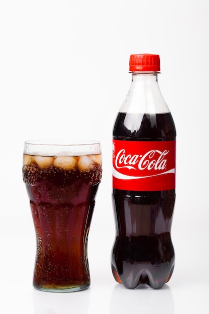 Foto close-up di un bicchiere di coca-cola su uno sfondo bianco