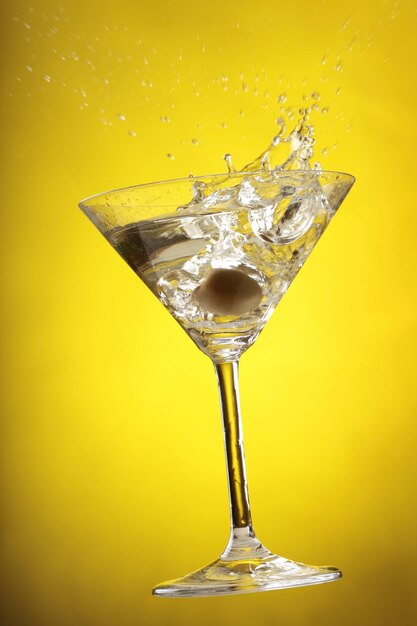 Close-up of cocktail splashing over yellow background