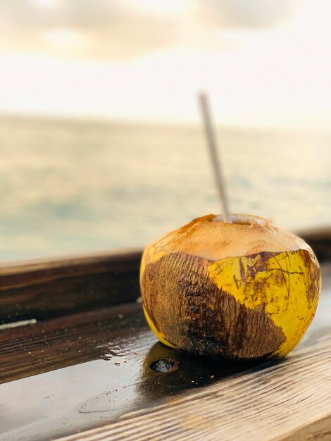 Foto prossimo piano di una noce di cocco sul tavolo contro il mare