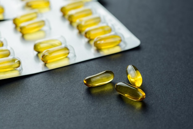 Photo close-up of cod liver oil capsules on table