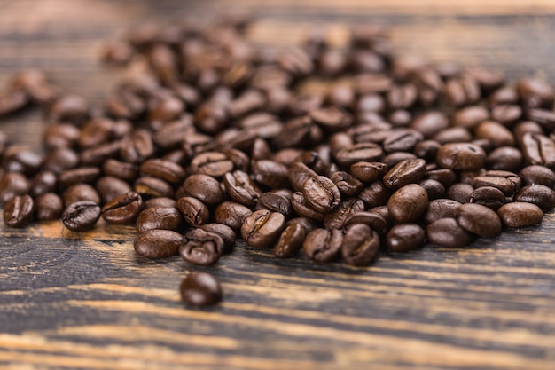 Close up coffee beans on grunge wooden background