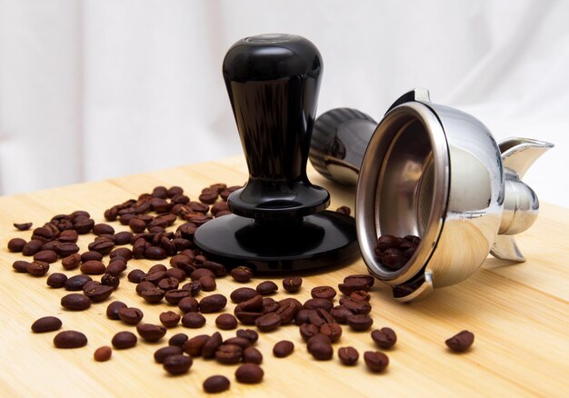 Photo close-up of coffee beans and portafilter on table