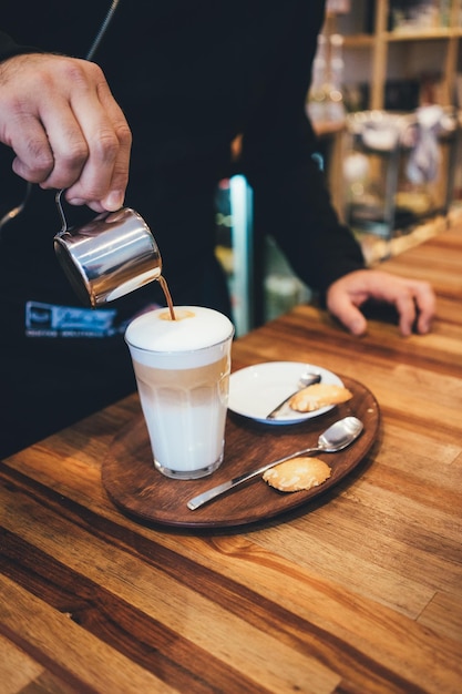 Photo close-up of coffee being poured in a cup on a table