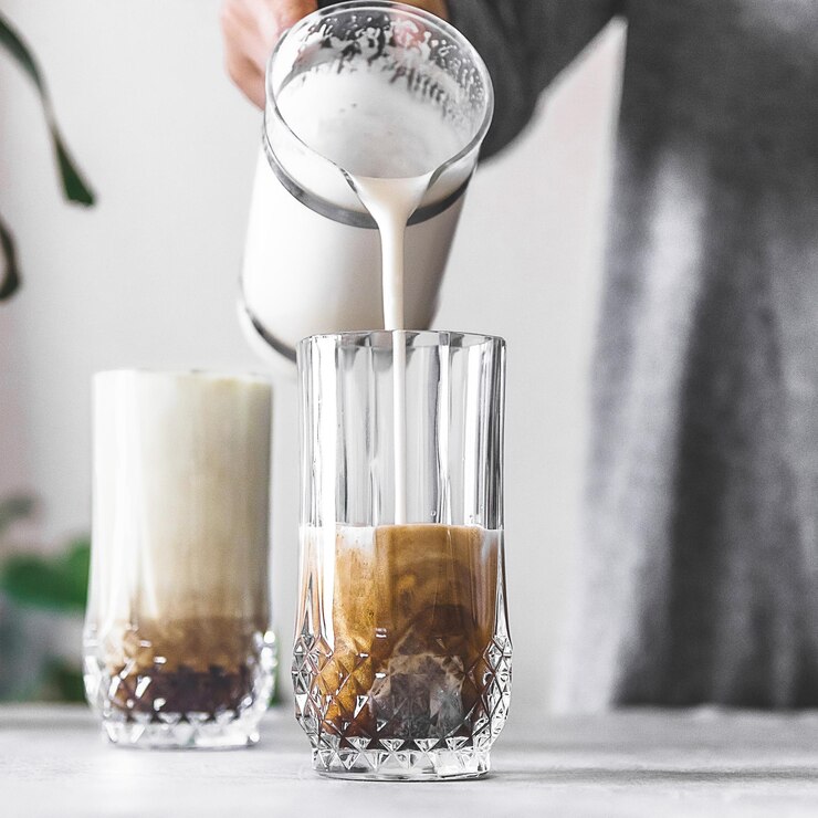 Photo close-up of coffee being poured into cup on table